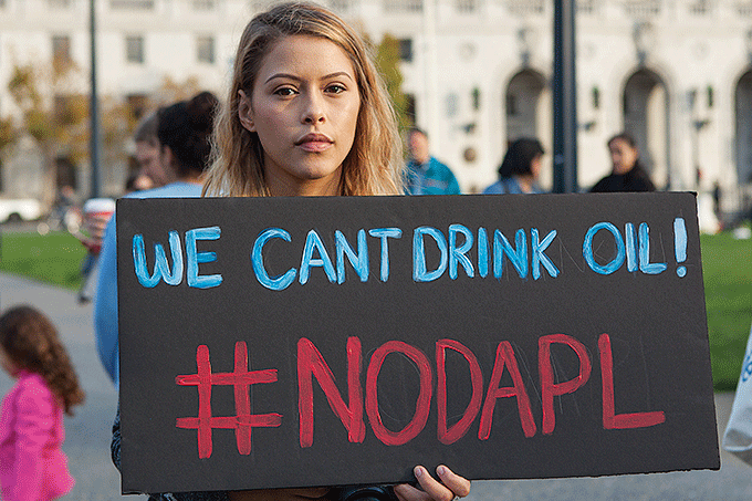 En ung kvinde demonstrer imod Dakota Access Pipeline i november 2016