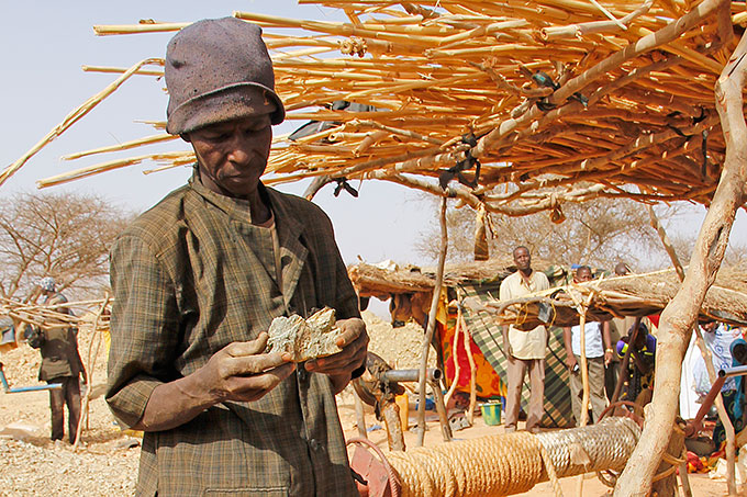 Minearbejder i Burkina Faso fremviser guldholdigt ler.