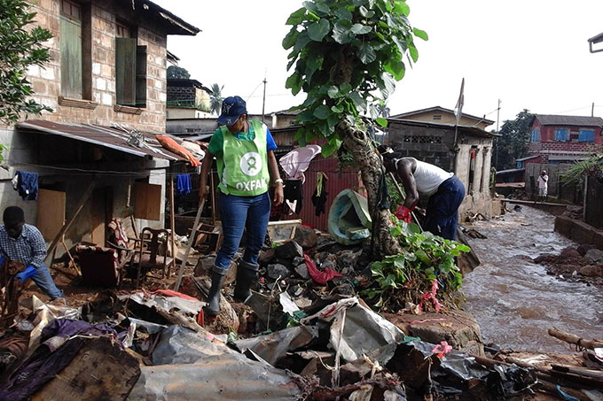En Oxfam-kollega hjælper med oprydningen efter katastrofen forrige uge. Oxfam sørger blandt andet for rent vand og hygiejnekit til tusindvis af de overlevende, så smitsomme sygdomme som kolera ikke spreder sig