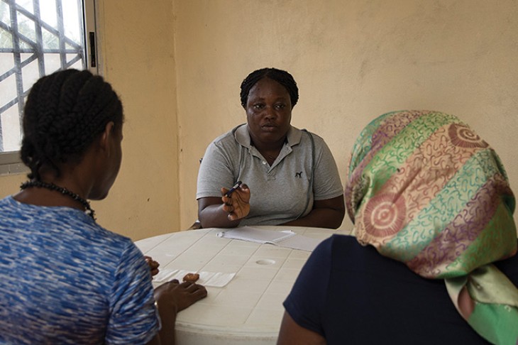 Rape survivor Janet and her mother talking to social worker Estella G-Dandy, who works for the FLOW programme in Liberia