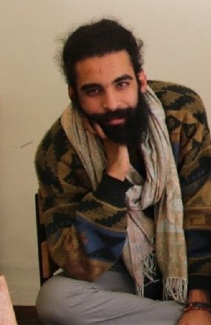 Ahmed Zarrouki på Café Liberté, under et af sine billeder fra den seneste demonstration.