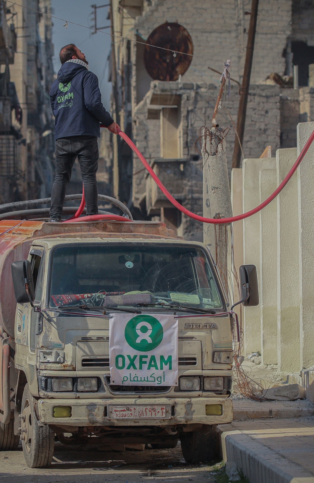 Oxfam is shown in the pictures delivering water to shelters in Aleppo city.